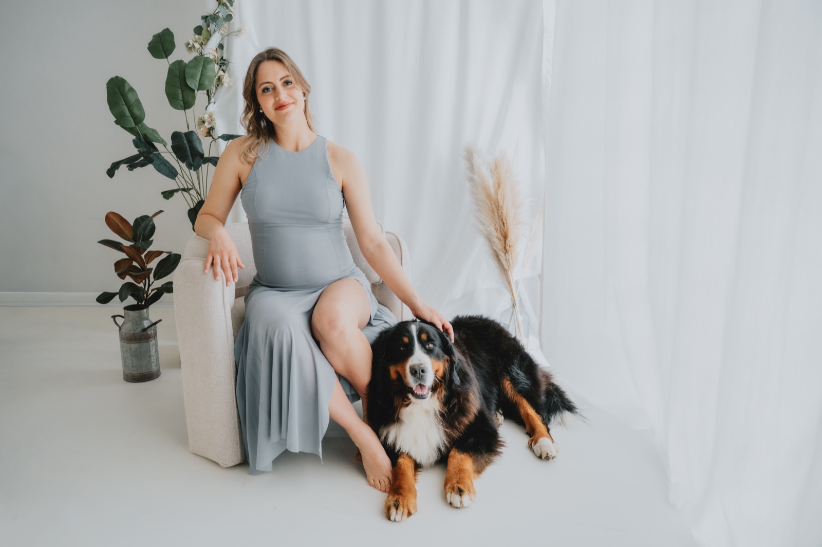 Futura mamma seduta in studio, con il cane accanto