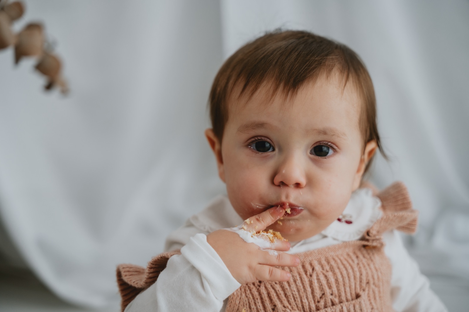 Bambina che si porta alla bocca un pezzo di torta