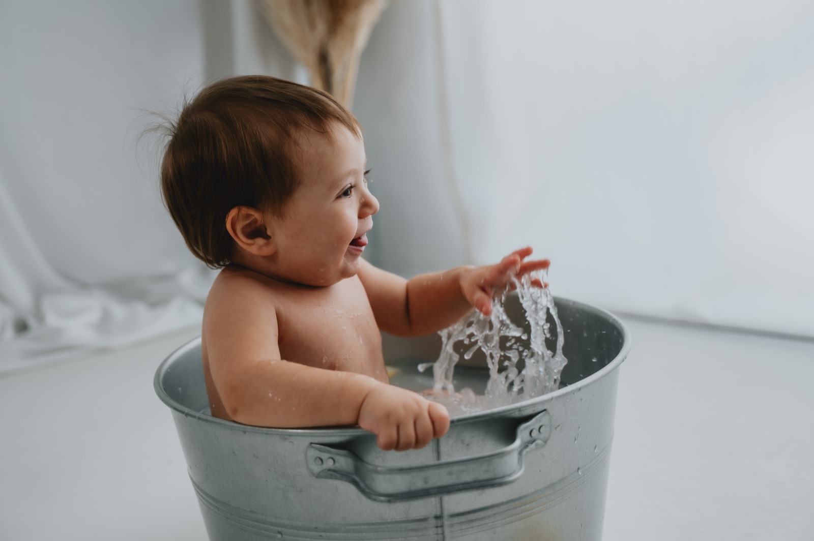 Bambina nella tinozza di zinco che gioca con l'acqua dopo la torta
