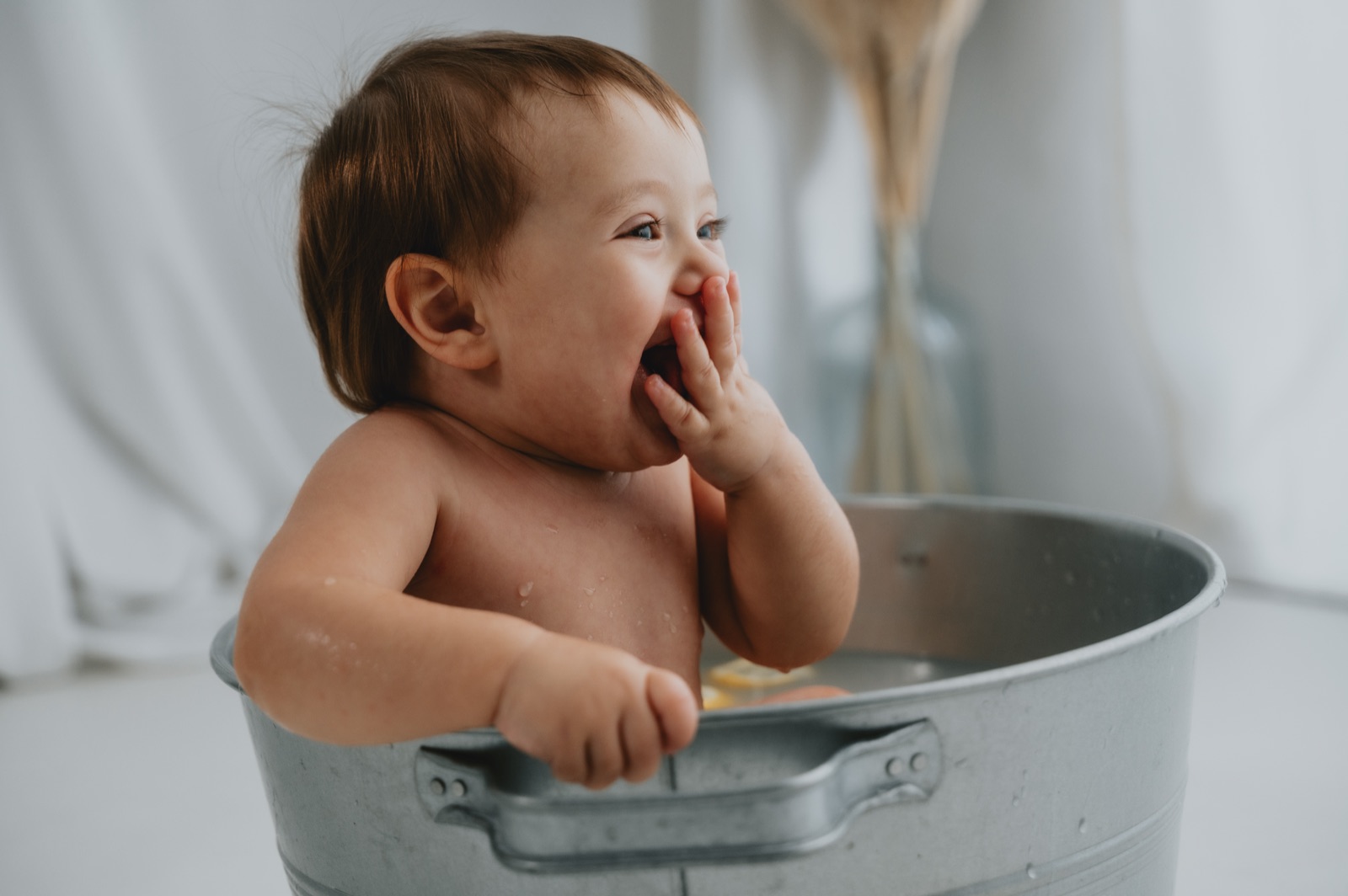 Bambina che ride dentro la tinozza durante il bagnetto