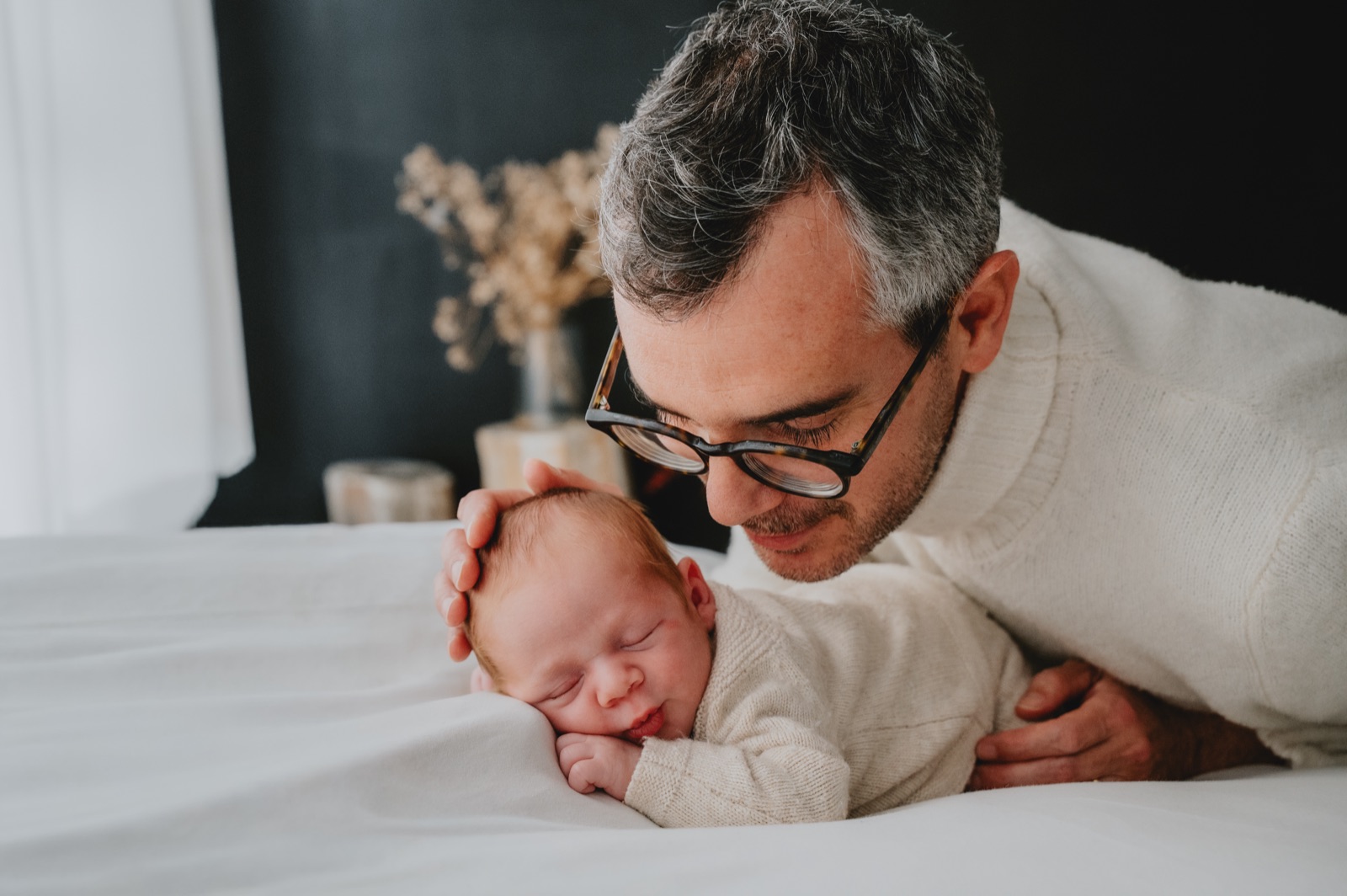 Papà chinato sul neonato addormentato