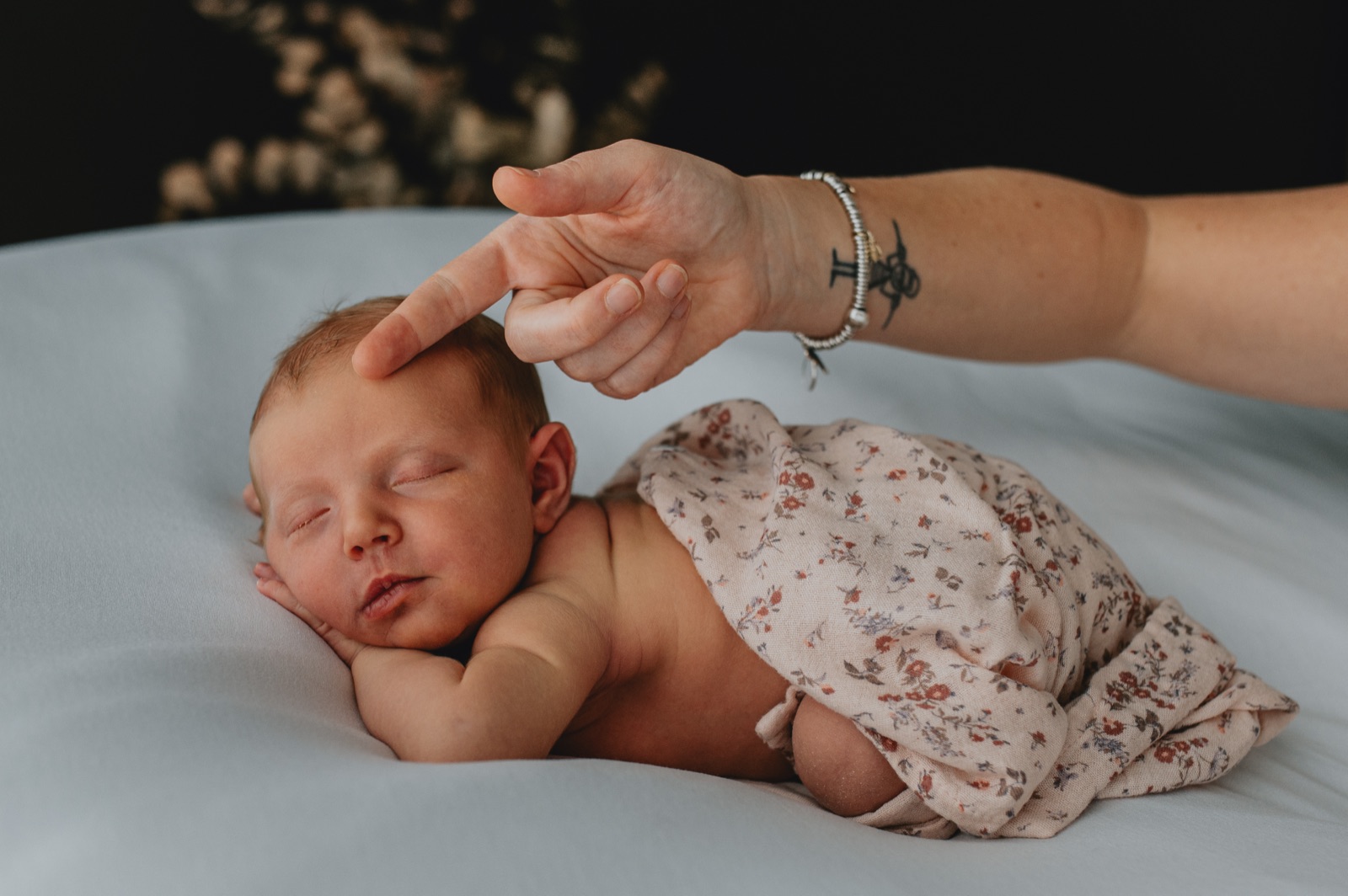 Una mano che accarezza la testa del neonato addormentato