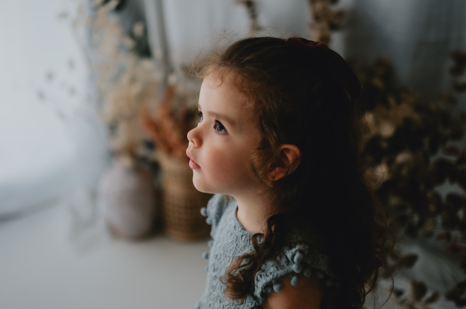 Bambina di profilo che guarda in alto, nella luce dello studio