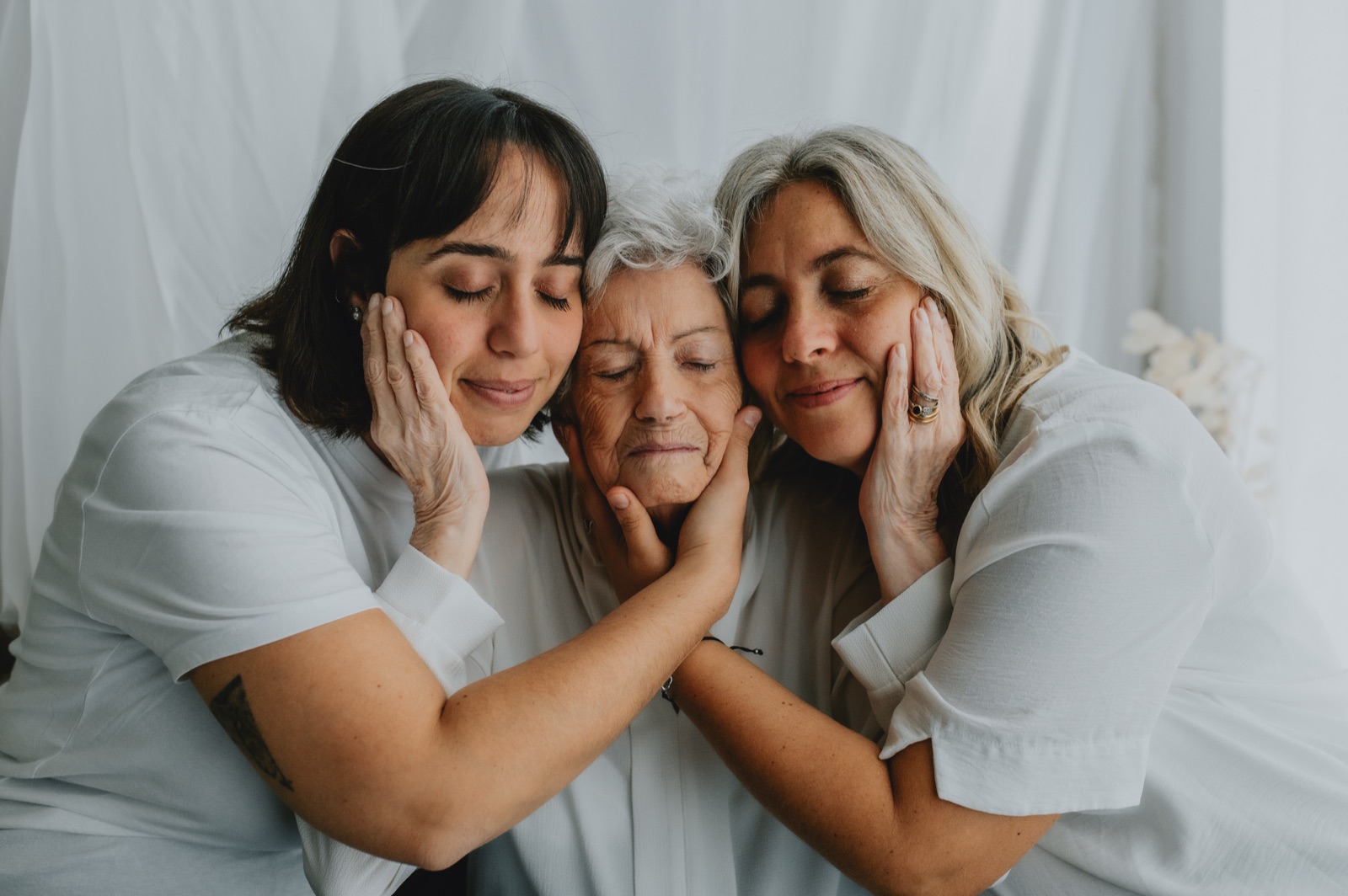 Due donne che appoggiano il viso a quello della nonna