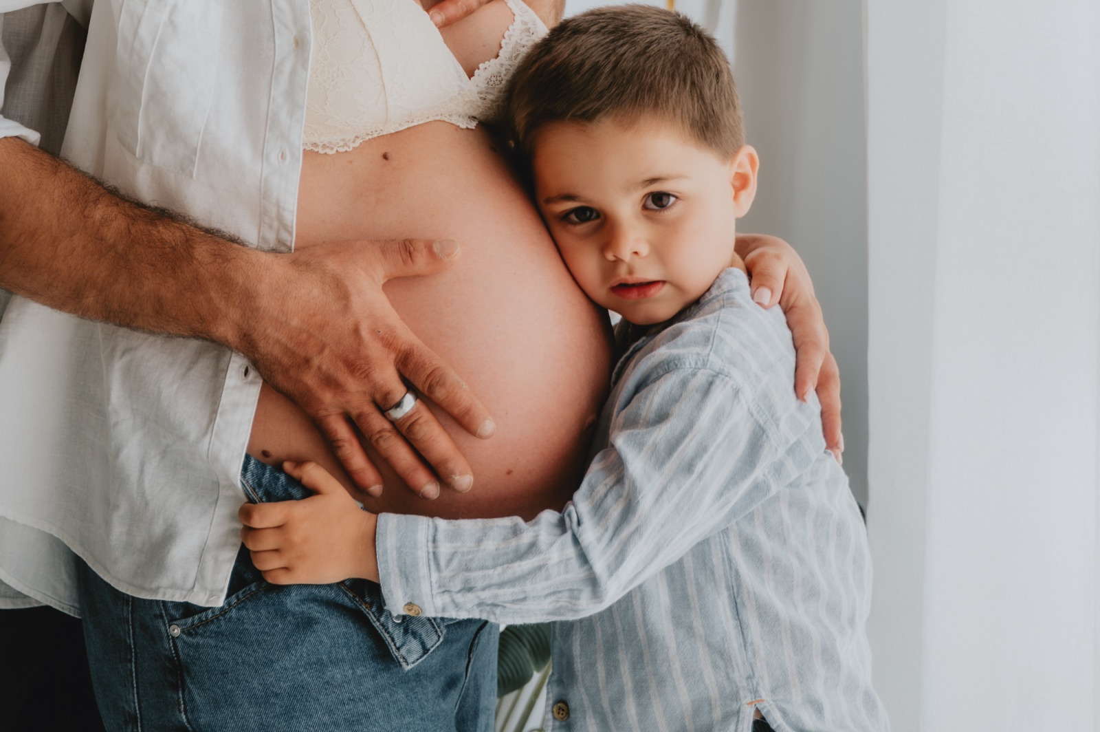 Bambino che appoggia la testa sul pancione della mamma