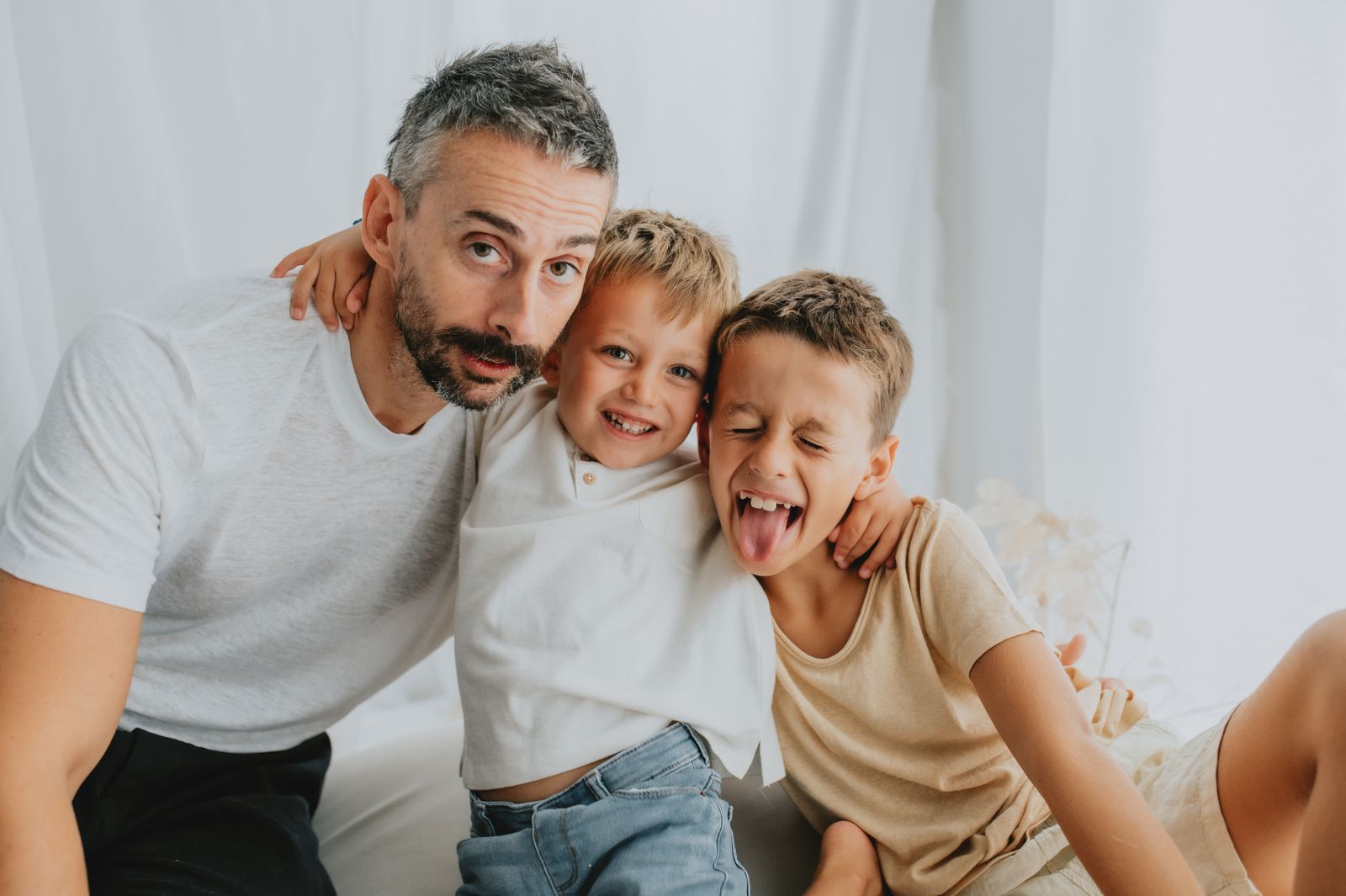 Papa' e due bambini che ridono insieme durante lo shooting di famiglia