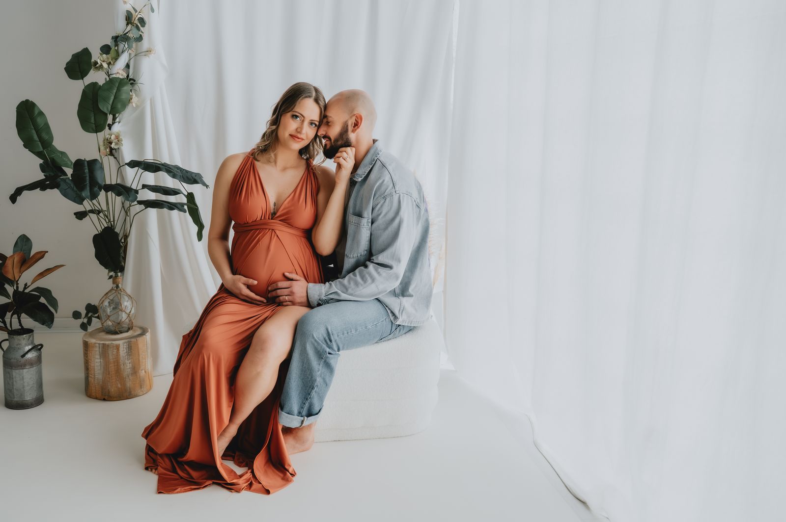 Coppia in attesa abbracciata durante uno shooting maternity in studio a Firenze