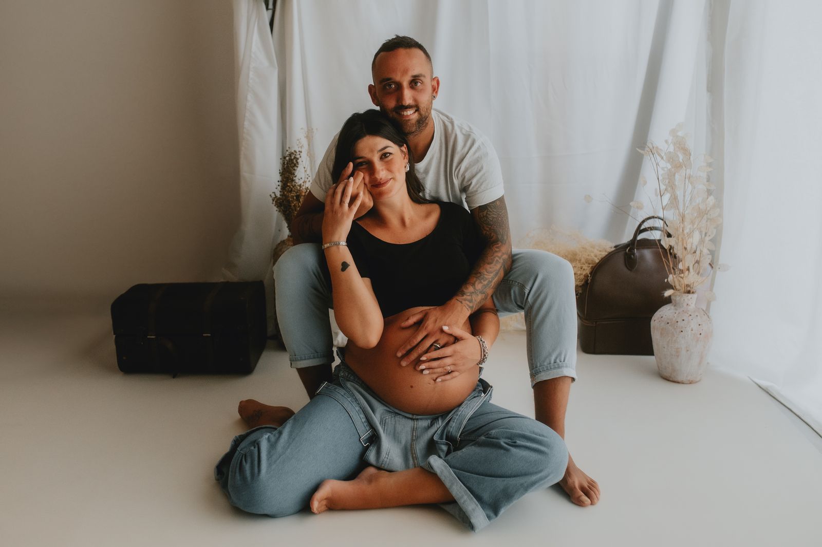 Famiglia in attesa seduta a terra nello studio fotografico di Firenze