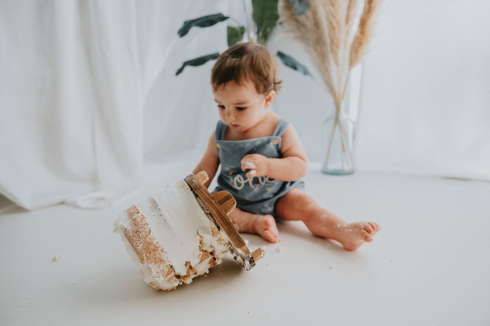 Bambino che rovescia la torta durante il servizio fotografico smash cake