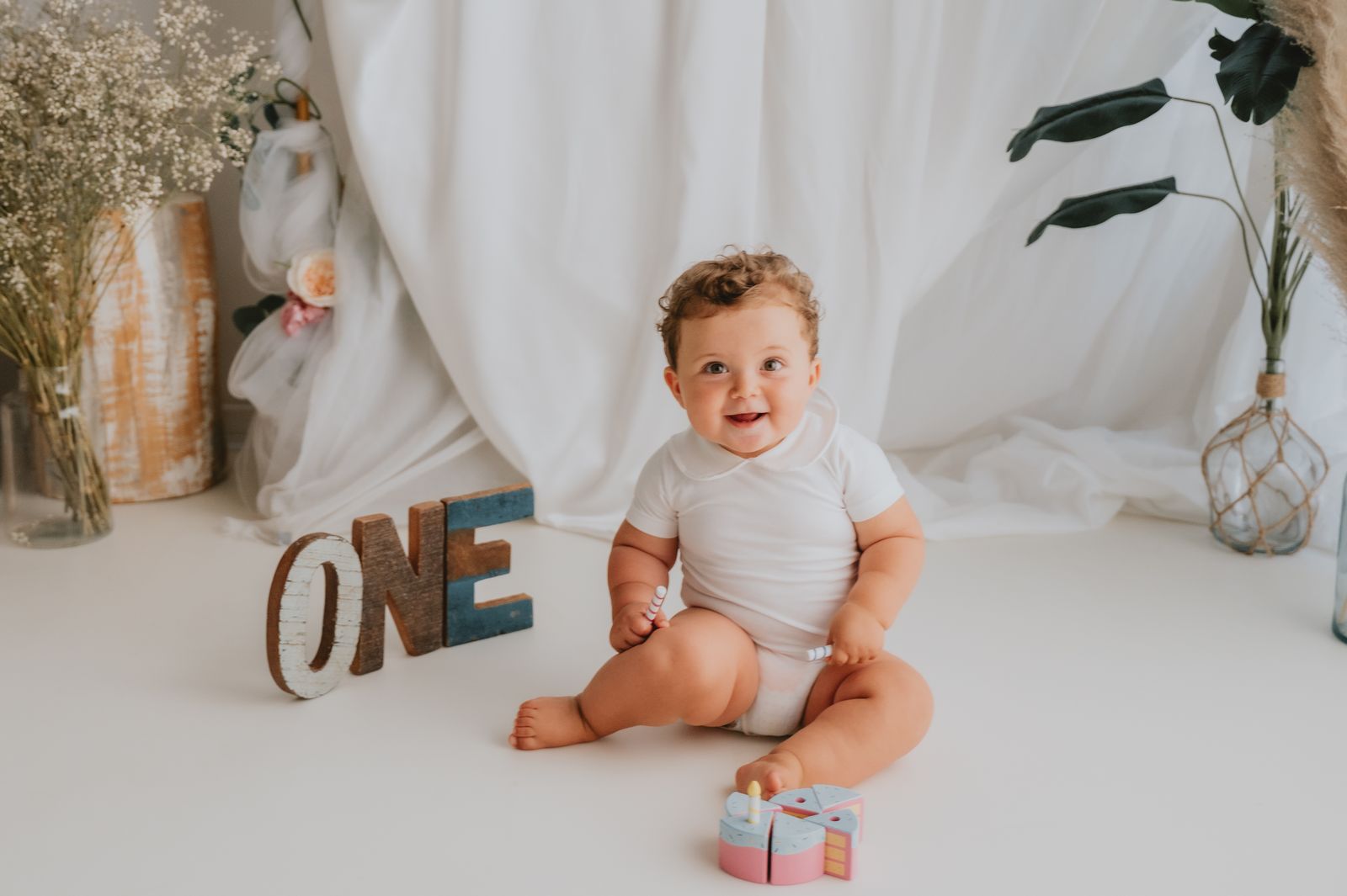 Bambino seduto accanto alla scritta ONE nell'allestimento dello smash cake