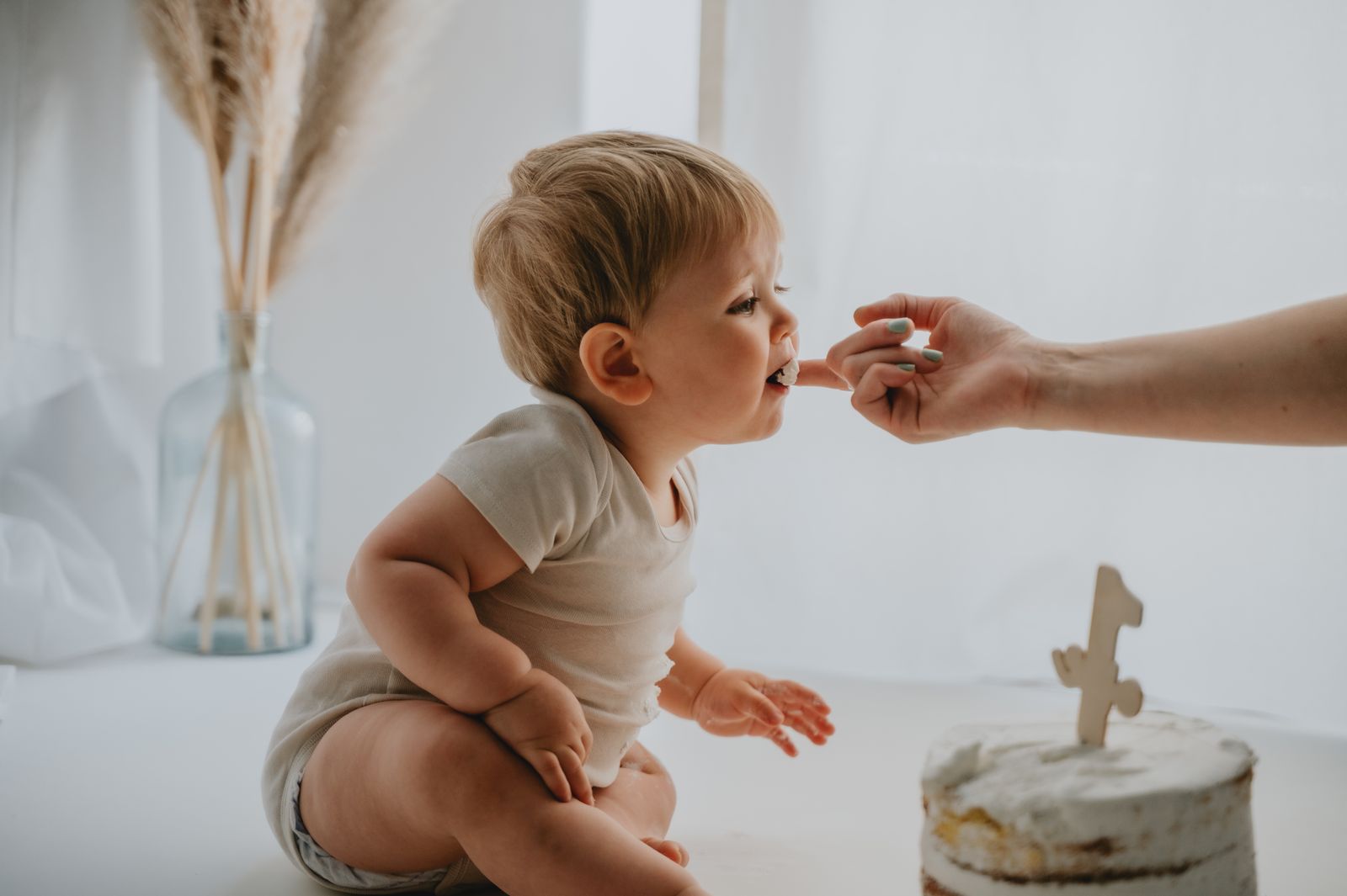 Bambino che assaggia la torta per la prima volta durante lo shooting
