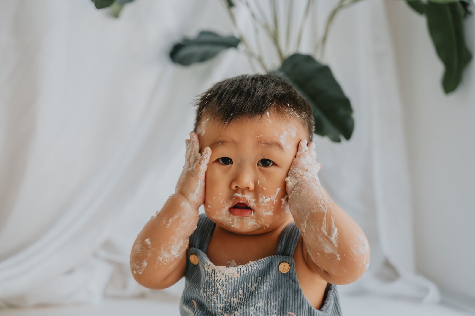 Bambino con il viso sporco di crema durante lo smash cake